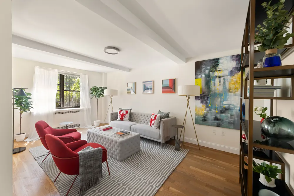 425 Central Park West, Residence 1D: the living room staged with a pair of red chairs and a large abstract canvas